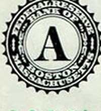 Close-up of the black Federal Reserve Bank of Boston seal with the letter A on a two-dollar bill